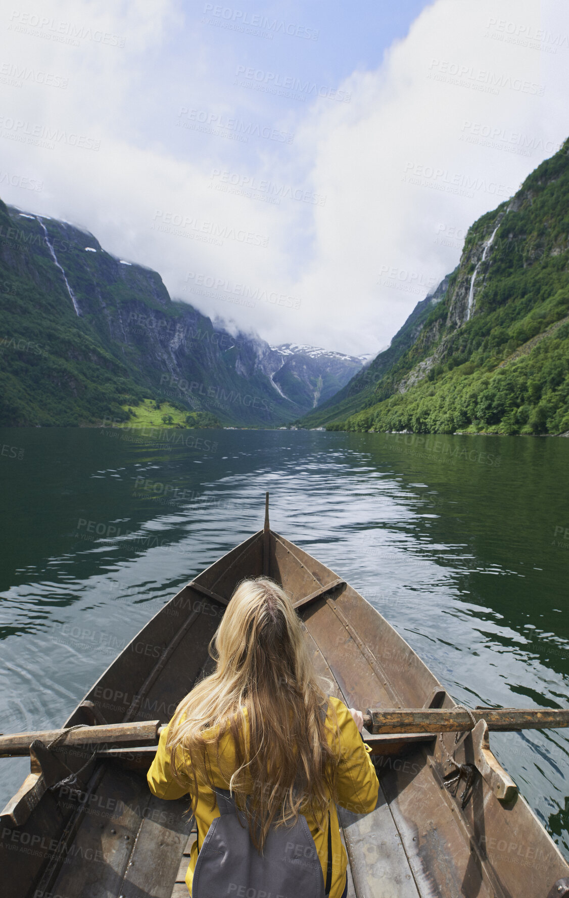 Buy stock photo Adventure, woman and river with rowing boat for travel, mountains and nature for holiday or vacation. Female person, journey and vessel on lake for sightseeing, back and wellness on trip in Norway 