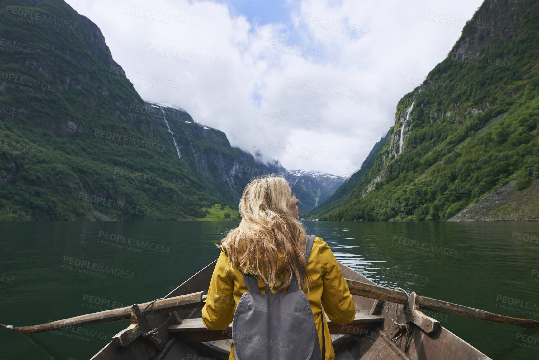 Buy stock photo Rowing, woman and river with boat for mountain adventure, travel and nature for holiday or vacation. Female person, journey and vessel on lake for sightseeing, back and wellness on trip in Norway 