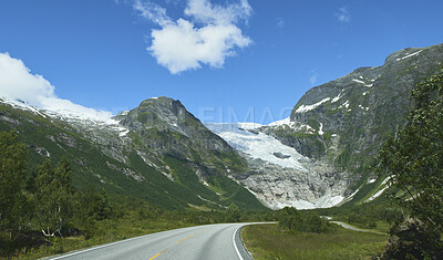 Buy stock photo Landscape, blue sky and mountain with road in nature for travel, adventure and holiday path. Snow, wanderlust or outdoor journey with scenic route, tourist highway and green foliage for vacation trip