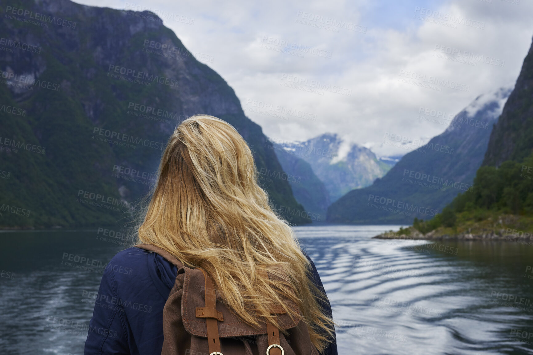Buy stock photo Back, woman and hiking by lake with mountain view, sightseeing and travel exploration for vacation. Person, backpacking and adventure outdoor with river for winter holiday, tourist trip and scenery.