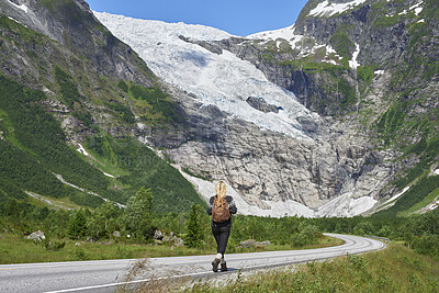 Buy stock photo Back, woman and hiking on road with backpack for travel, adventure and backpacking holiday. Mountain, female person and walking for trekking journey, glacier scenery and explore nature on vacation