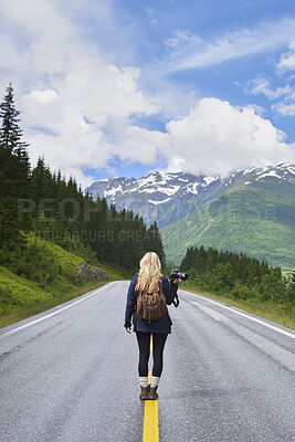 Buy stock photo Woman, backpack and camera on road with mountain view, sightseeing or travel exploration for vacation. Back, person and photographer outdoor with equipment for winter holiday, adventure and scenery.