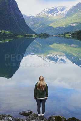 Buy stock photo Sky, mountain and woman by lake in nature for winter vacation, destination or holiday. Travel, snow and back of female person by river for outdoor scenery on weekend trip with sustainable location.