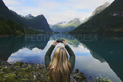 Buy stock photo Woman, mountain photography and outdoor by lake for travel adventure, holiday or hiking trip. Female person, river and phone screen for picture, back and sightseeing with glacier for tourist view