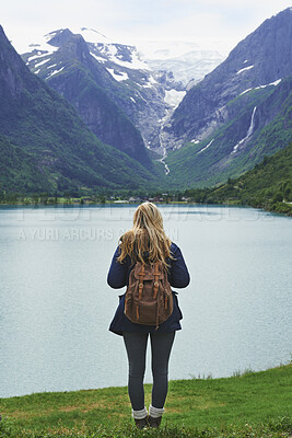 Buy stock photo Backpack, mountain and woman by river in nature for winter vacation, destination or holiday. Travel, snow and back of person by lake for outdoor scenery on weekend trip with sustainable location.