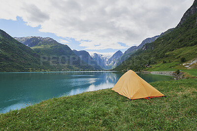 Buy stock photo Nature, travel and camping with tent at lake for weekend getaway, mountain trip or natural tourism. Landscape, water and shelter at campsite for countryside vacation, scenic environment or wanderlust