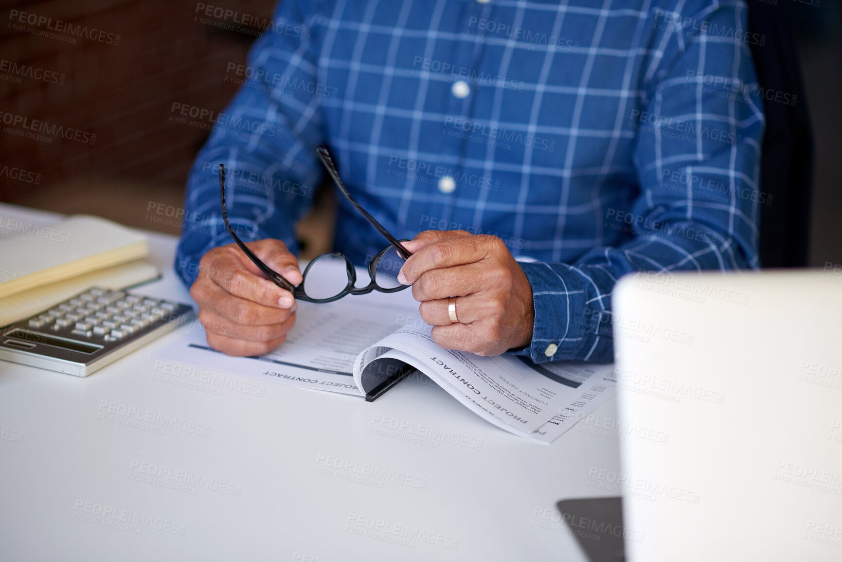 Buy stock photo Contract, glasses and hands of businessman in office with reading documents for finance project. Calculator, paperwork and male financial manager with laptop for feedback on investment proposal.