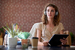 beautiful woman using tablet computer with stylus pen listening to music wearing headphones