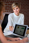 two business women using laptop computer working in office sharing ideas colleague discussing financial information on screen