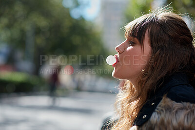 Buy stock photo Blowing, gum and woman in city, profile and cool with streetwear on weekend break or travel outdoor. Trendy, fashion and person with bubblegum on urban street, relax and Gen z with attitude and space