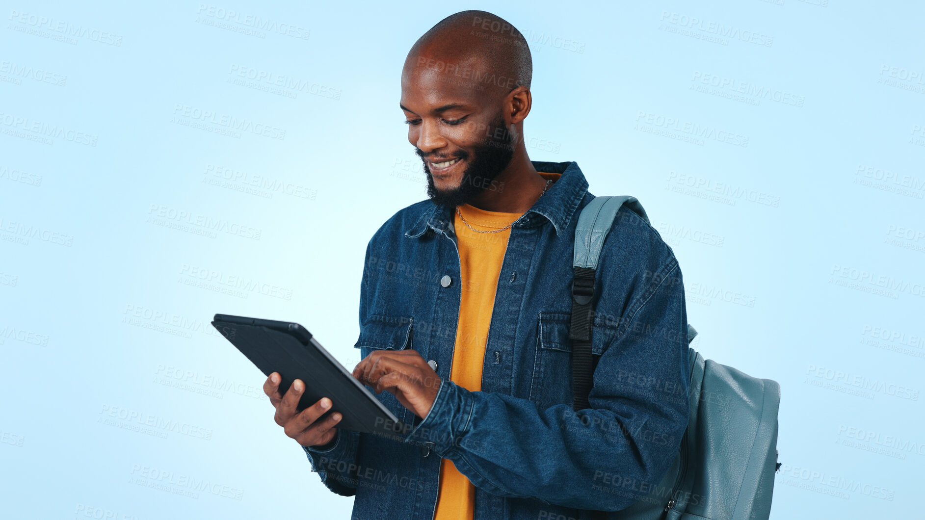 Buy stock photo Black man, student and research with tablet in studio for higher education on a blue background. Male person, academic or learner with smile, bag or technology for online learning course or study app