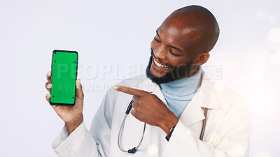 Buy stock photo Black man, green screen and doctor pointing with phone in studio for medical app for consultation. Tech, mockup space and healthcare worker with appointment booking display by white background bokeh
