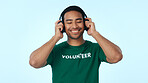 Studio, volunteer and man with headphones, charity and listening to music with subscription on break. Blue background, humanitarian and happy person with tech for playlist, ngo and streaming audio