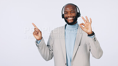 Buy stock photo Black man, portrait or pointing with headset for business advertising on a studio background. Businessman, agent or smile with OK sign for good customer service, CRM advice or helpful tips on space