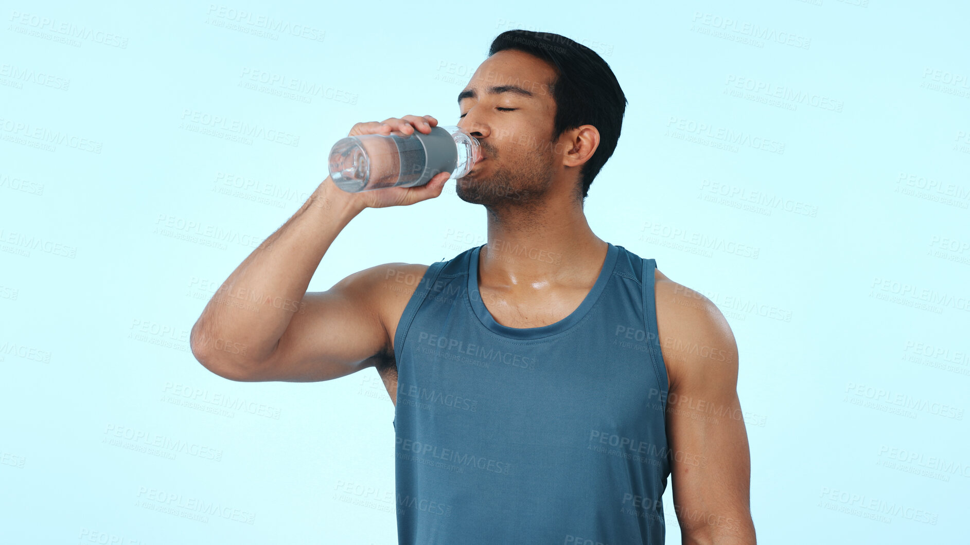 Buy stock photo Exercise, drinking and man with water in studio for hydration, electrolytes and aqua for fitness. Personal trainer, space and person with minerals for wellness, health and thirsty on blue background
