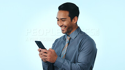 Buy stock photo Phone, happy and businessman in studio for notification, email or contact for feedback on investment. Technology, typing and male financial manager on mobile app for finance report by blue background