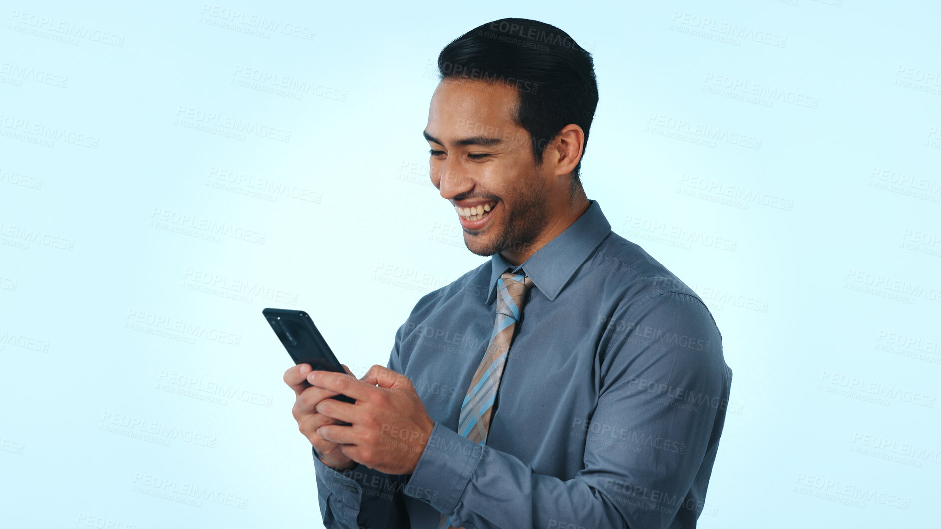 Buy stock photo Phone, happy and businessman in studio for notification, email or contact for feedback on investment. Technology, typing and male financial manager on mobile app for finance report by blue background