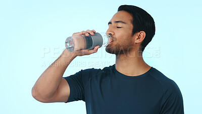 Buy stock photo Fitness, drinking and man with water in studio for hydration after exercise, training and workout. Personal trainer, space and person with liquid for wellness, health and minerals on blue background