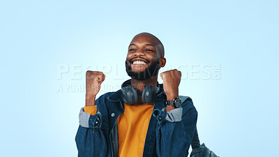Buy stock photo Happy, black man and student winning with fist pump in studio for good news on a blue background. Excited, male person or learner with smile for achievement, accomplishment or celebration on space
