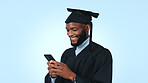 Happy, black man and graduation with phone in studio for online scholarship on a blue background. Male person, graduate or student with smile, mobile smartphone or app for academic results on space