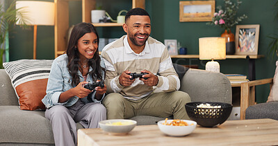 Buy stock photo Happy couple, video games and playing with food on sofa for entertainment or online match in home. Man, woman or smile with controller or snacks for console gaming, esport or fun bonding in house