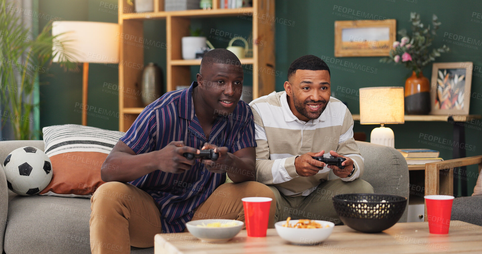 Buy stock photo Happy men, video games and playing with food on sofa for entertainment or online match in home. Male people, friends or smile with controller or snacks for console gaming or fun bonding in house