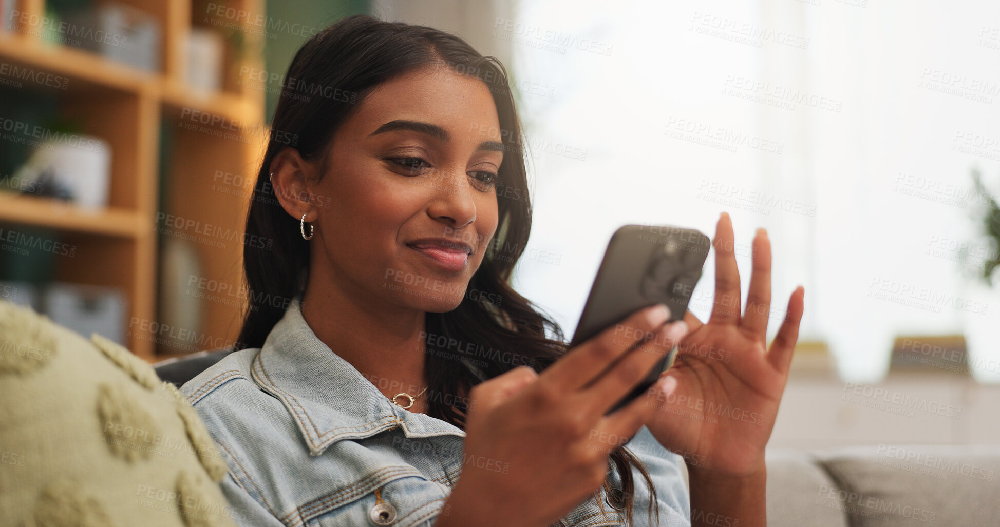 Buy stock photo Woman, smile and scroll in apartment with phone, online dating notification or reading text message. Happy, person and relax in house with tech, mobile app and social media for digital communication.