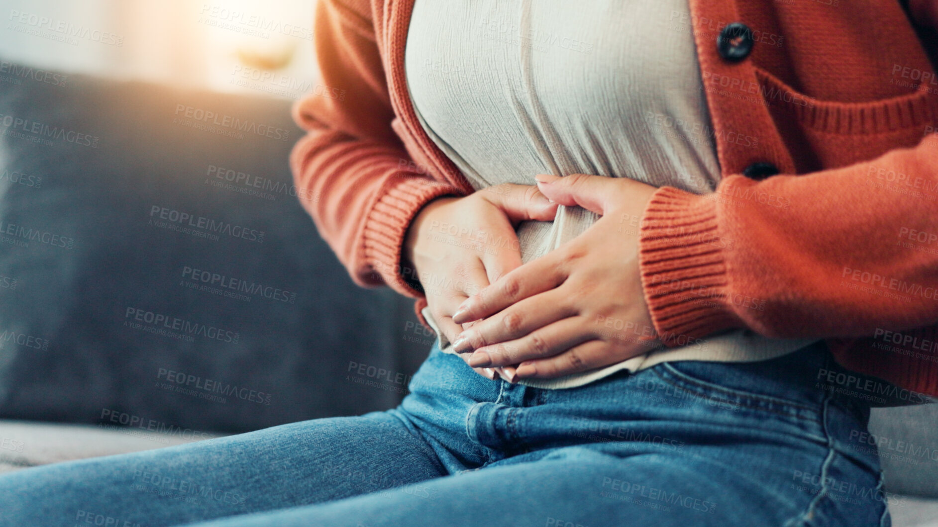 Buy stock photo Cramps, menstruation and hands of woman on sofa in home for period pain, healthcare and stomach virus. Endometriosis, constipation and bloating with person in living room of house for pms or diarrhea