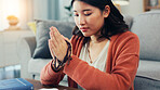 Praying, rosary and Asian woman in home for religion, worship and belief for gratitude. Christianity, religious and person in prayer for peace, blessings and guidance with spiritual jewelry in house