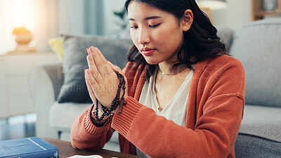 Buy stock photo Praying, rosary and Asian woman in home for religion, worship and belief for gratitude. Christianity, religious and person in prayer for peace, blessings and guidance with spiritual jewelry in house