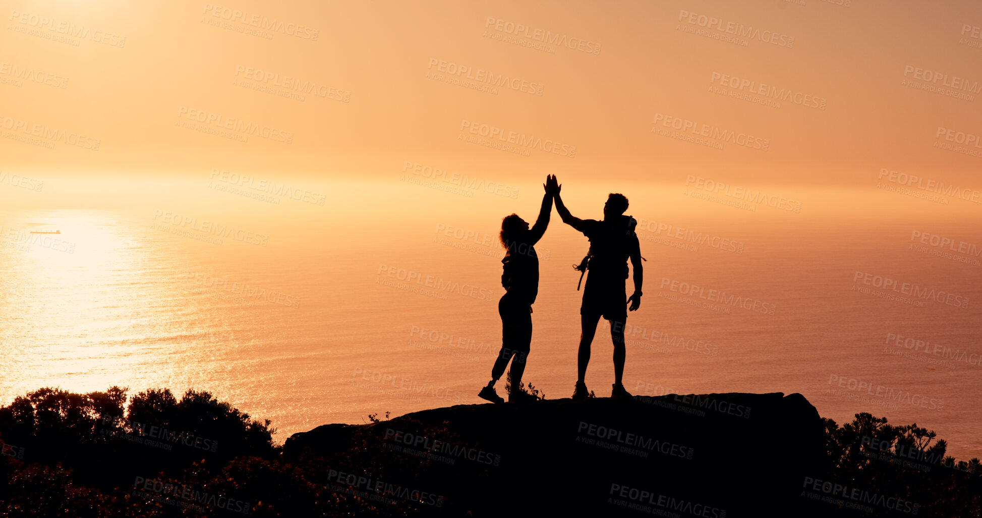 Buy stock photo People, silhouette or hiking with high five on mountain cliff for achievement or accomplishment. Sunset, hikers or team with hands together in nature for trekking journey, success or conquer on space