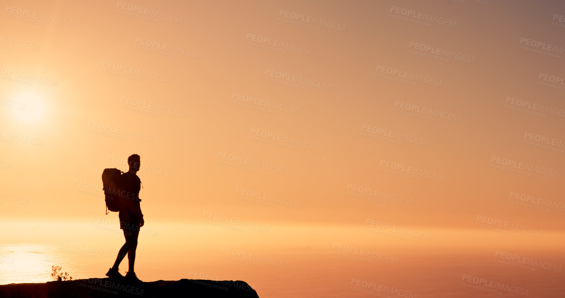 Buy stock photo Sunset, hiking and man on mountain for adventure, mockup space and sightseeing on holiday or travel. Outdoor, sky and person with scenery in nature, silhouette and break on vacation for exploration