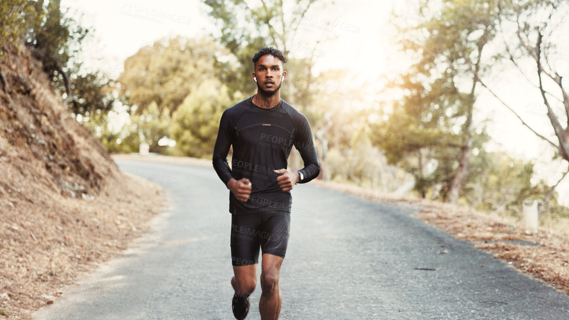 Buy stock photo Man, running and earphones on mountain road for fitness, cardio development and training with podcast. Male person, runner and audio tech in nature for healthy body, outdoor challenge and music