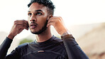Earphones, fitness and thinking with man outdoor for start of cardio training or workout routine. Exercise, music and vision with runner in nature for challenge, physical improvement or wellness