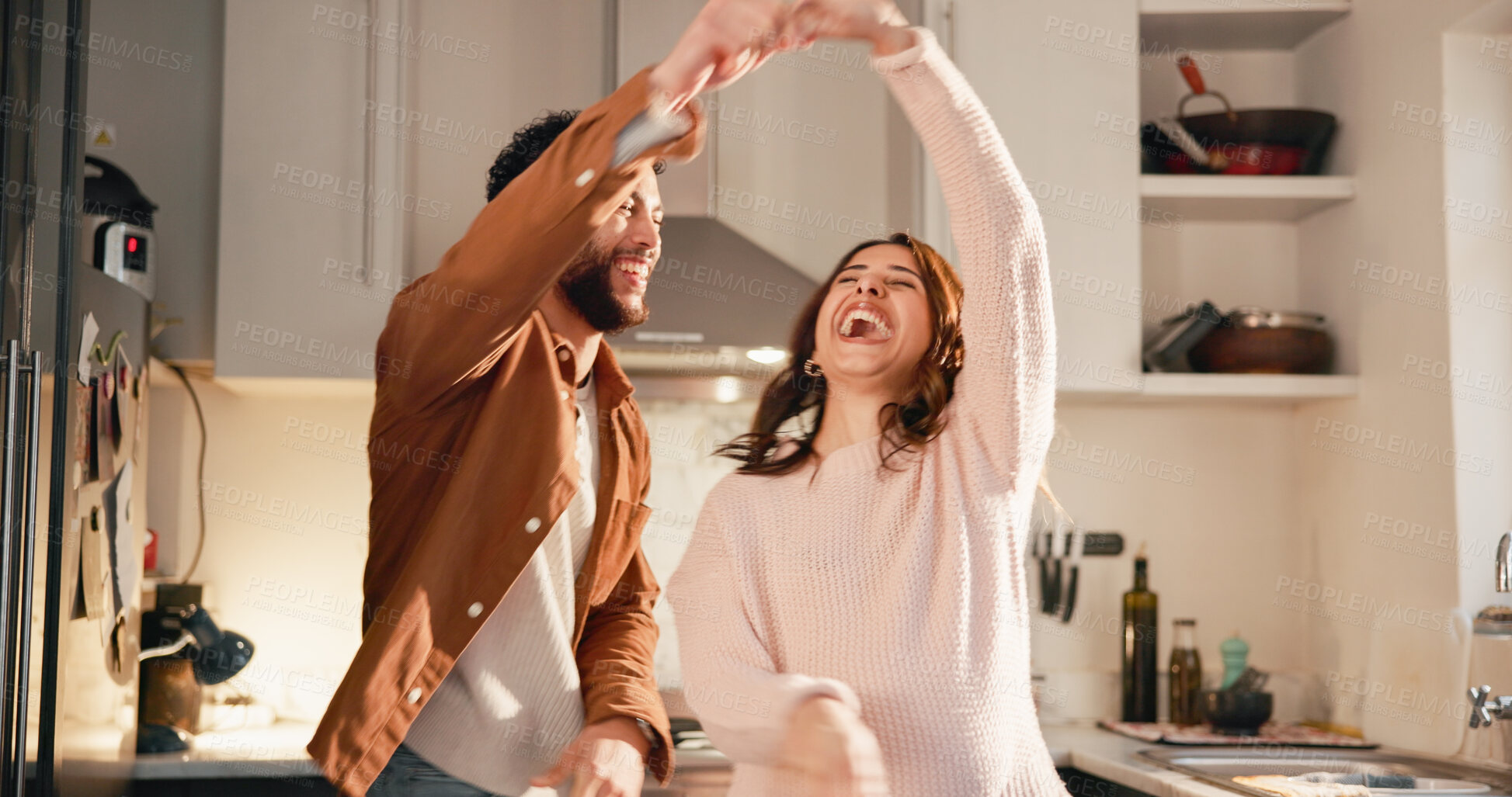 Buy stock photo Laugh, dance and couple in kitchen for love, anniversary celebration or happiness with partner. Spin, funny woman and man in home with music, holding hands or romantic rhythm for healthy relationship
