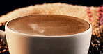 Closeup, coffee and beans in cafe with froth, warm drink and caffeine in latte for breakfast beverage. Mug, brown liquid and cappuccino in restaurant with foam, strong espresso and delicious brew.