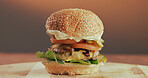 Beef, burger and fast food in restaurant for takeaway order, lunch or catering service for hospitality. Delicious, meal and vegetables on wooden board with meat, lettuce and tomato for tasty dish.