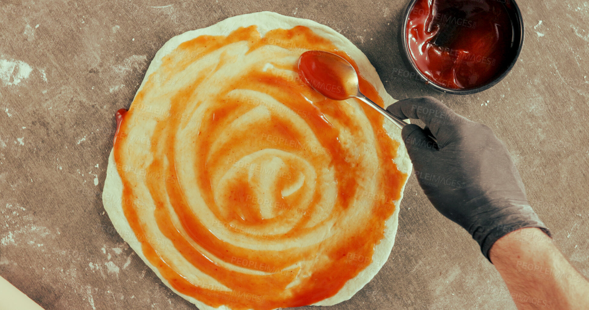 Buy stock photo Hand, pizza and dough in restaurant with tomato sauce, spoon and glove for food preparation process. Above, person and chef cooking in diner with Italian cuisine, catering or hygiene for hospitality.