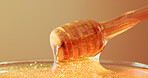 Studio, bowl and honey on wooden dipper, natural antioxidant and organic ingredient for sweetener. Syrup, sticky liquid and utensil with raw sugar for immunity, healthy food and brown background