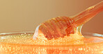Studio, bowl and honey on wooden utensil, natural antioxidant and organic ingredient for sweetener. Syrup, sticky liquid and dipper with raw sugar for immunity, healthy food and brown background