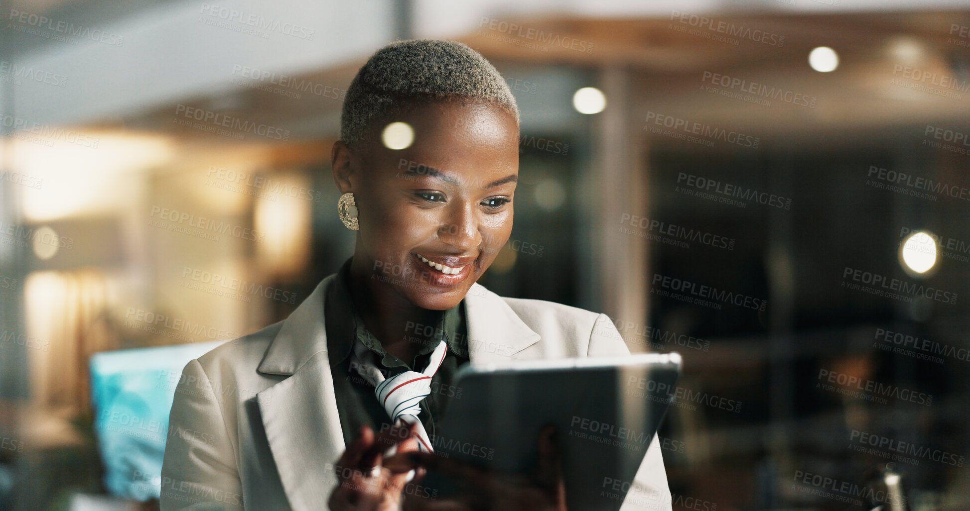 Buy stock photo Night, reading or woman with tablet by window, publishing deadline or review story for digital site. Bokeh, tech or African journalist with grammar check app, late article editing or smile in office