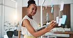 Black woman, writing or planning with tablet on glass board in office for schedule, task or agenda. Female person, employee or taking notes with technology for brainstorming ideas or project reminder