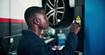 Black man, mechanic and power with vehicle lifter for automotive service, repair or fix in workshop. Male person, engineer or auto electrician lifting car with machine for inspection or diagnostics