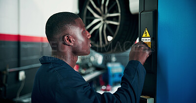 Buy stock photo Black man, mechanic and power with vehicle lifter for automotive service, repair or fix in workshop. Male person, engineer or auto electrician lifting car with machine for inspection or diagnostics