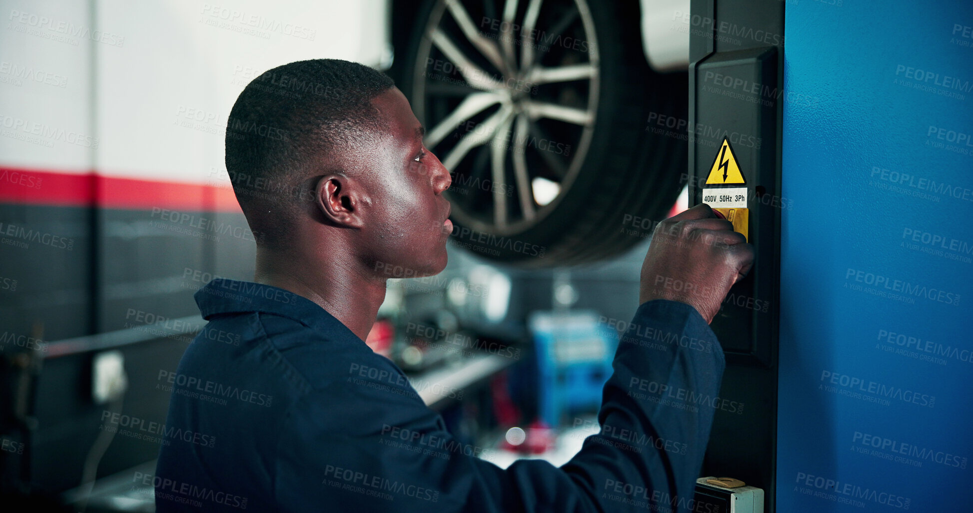 Buy stock photo Black man, mechanic and power with vehicle lifter for automotive service, repair or fix in workshop. Male person, engineer or auto electrician lifting car with machine for inspection or diagnostics