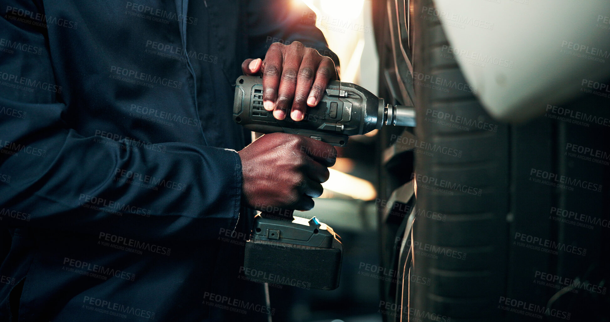 Buy stock photo Man, hands and car mechanic with power tool on tire for wheel change, repair or fix in workshop. Male person, engineer or technician with equipment for bolts, vehicle maintenance or calibration test