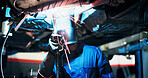 Mechanic, welding and man with tools by car for diagnostics, maintenance and auto service. Workshop, flare and technician with equipment for vehicle inspection, fixing and engine repair with helmet