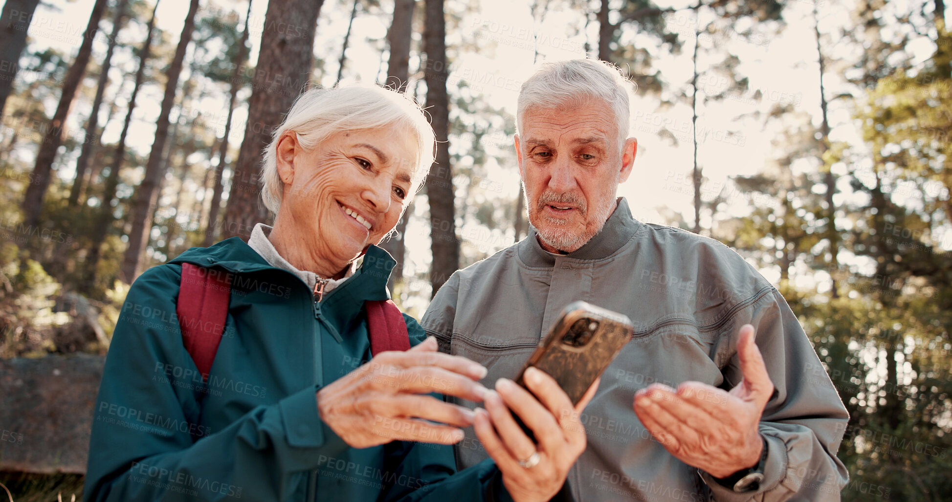 Buy stock photo Hiking, old couple and happy with smartphone for map, talk and search for travel destination on web. Outdoor, backpacker and elderly people with mobile for direction, low angle and adventure in woods