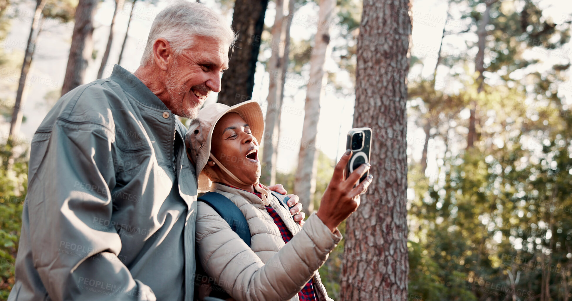 Buy stock photo Nature, hiking and selfie with people and smile for adventure with retirement, wellness and health. Travel, picture and mature interracial couple with digital tech for social media, memory and post