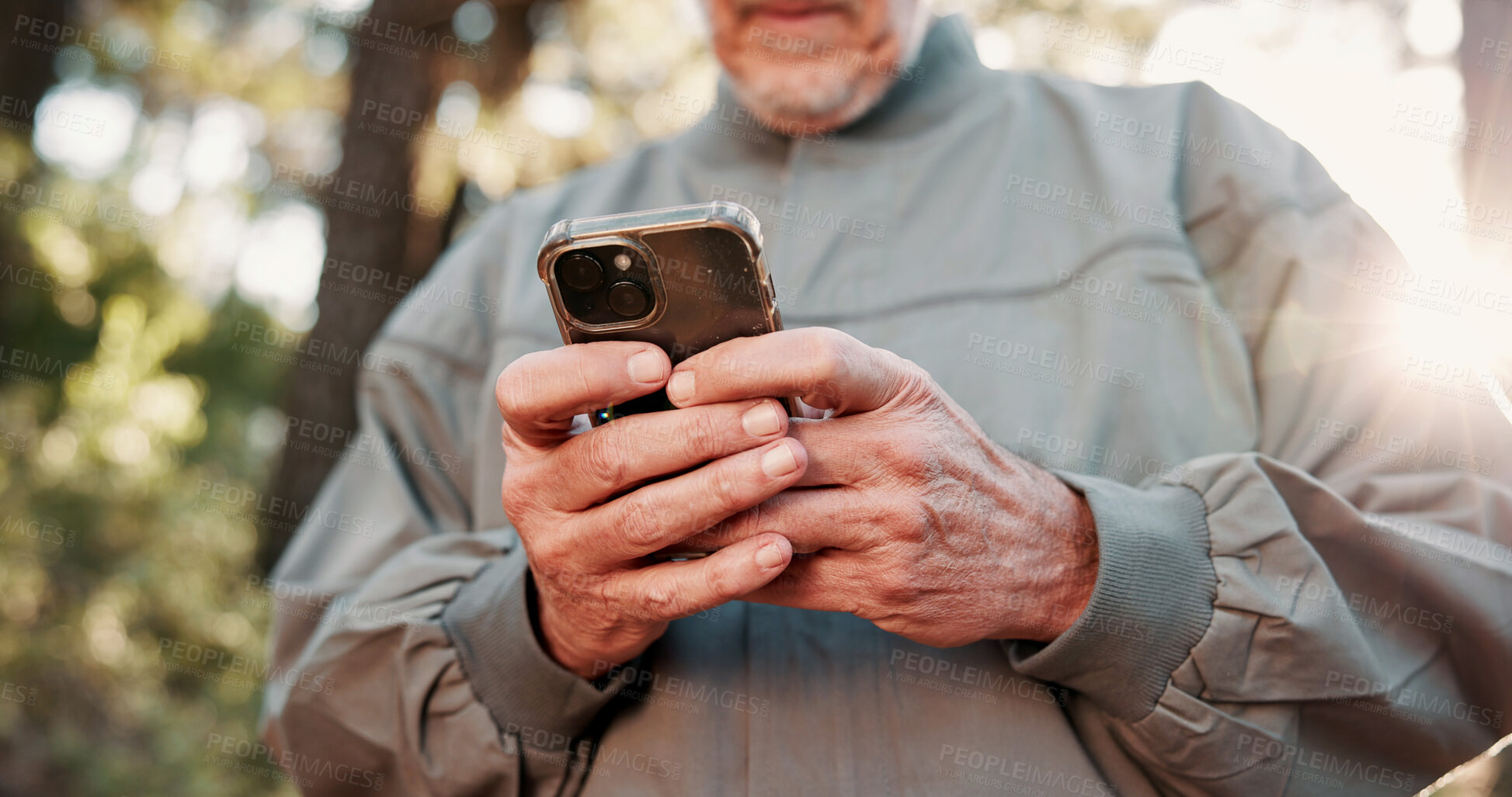 Buy stock photo Hiking, phone and hands of senior man in forest for wellness, fresh air and online for direction. Travel, morning and elderly person on nature trail for adventure, health and exercise on smartphone